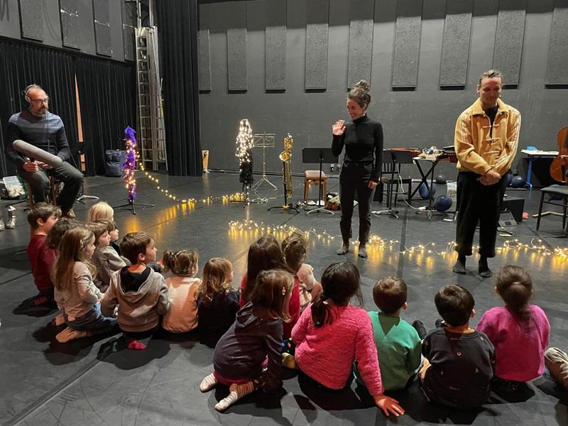 des enfants devant des artistes dans une salle de spectacle