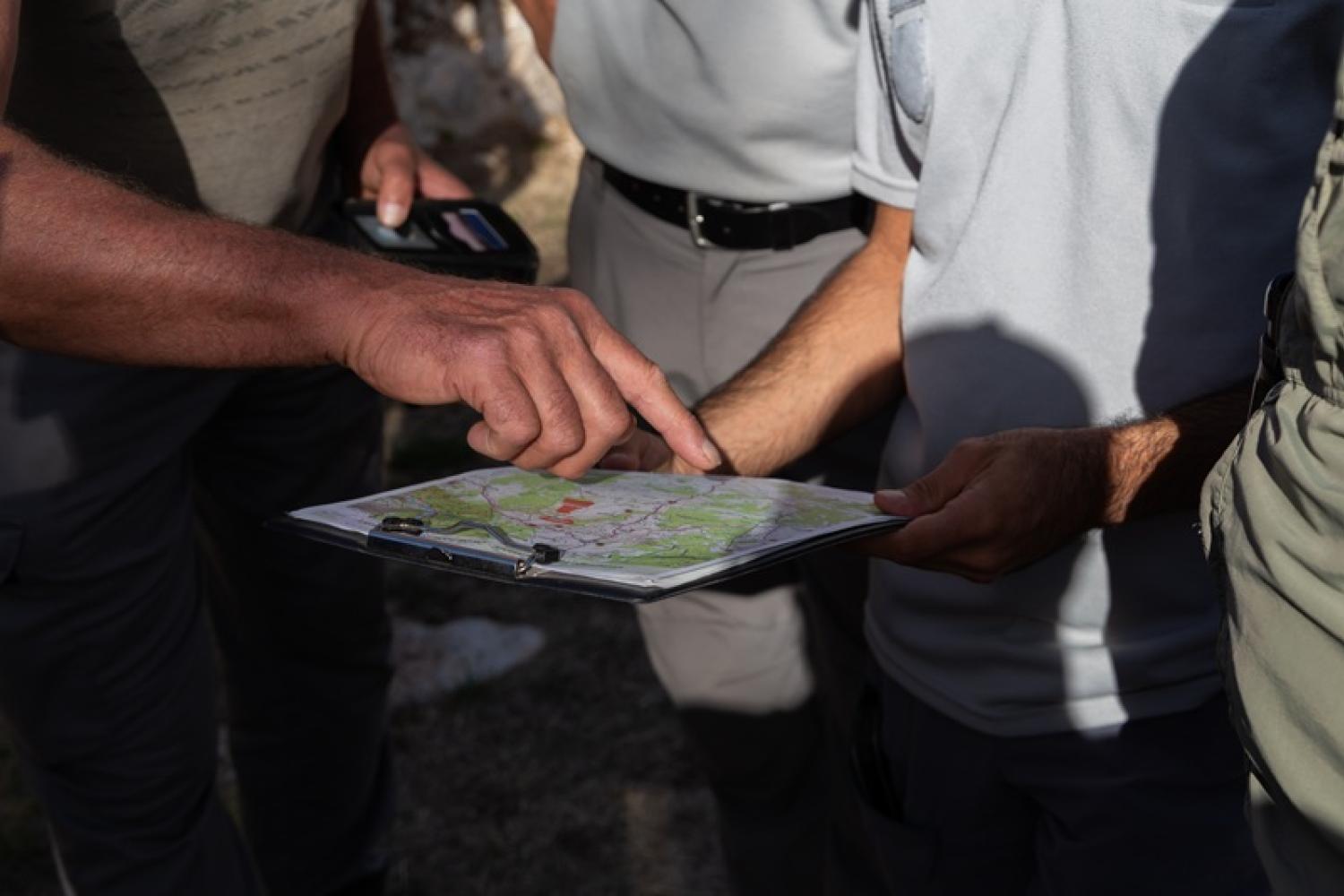 un garde moniteur pointe un endroit sur une carte